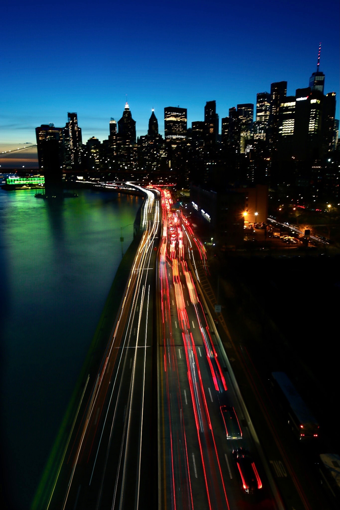 Manhattan skyline with traffic light trails at night