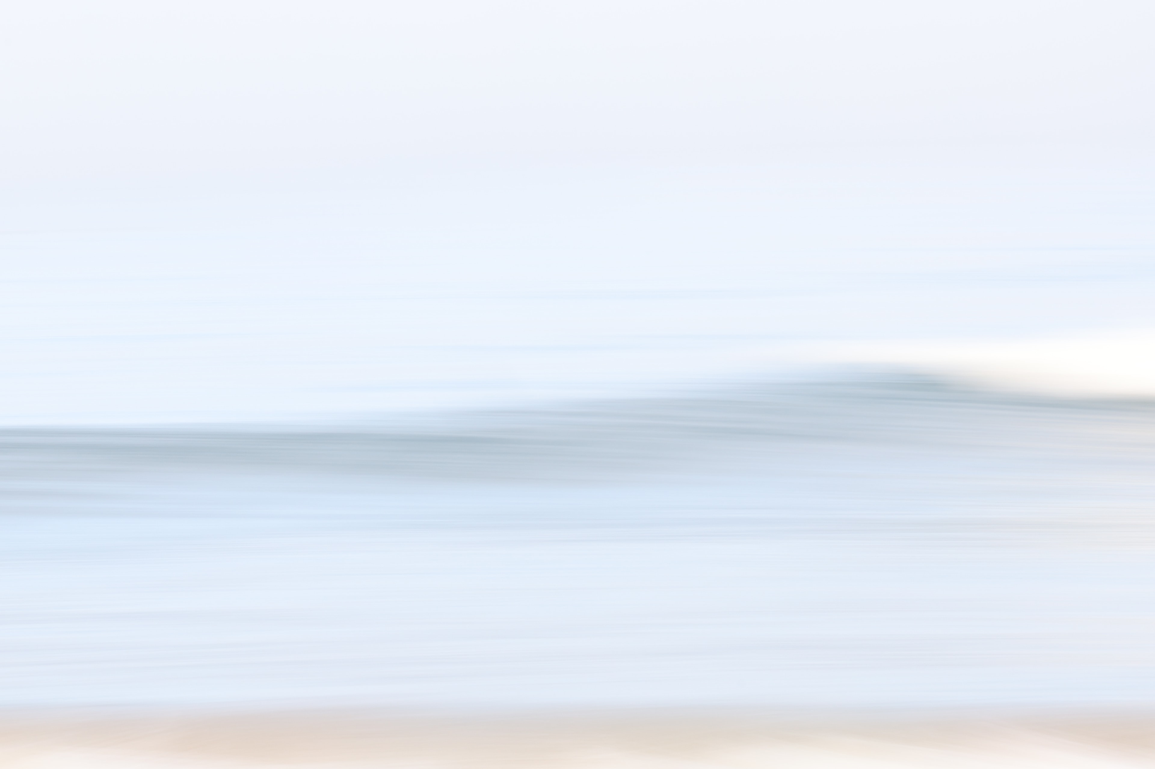 Long exposure seascape with a cresting wave and sandy shore
