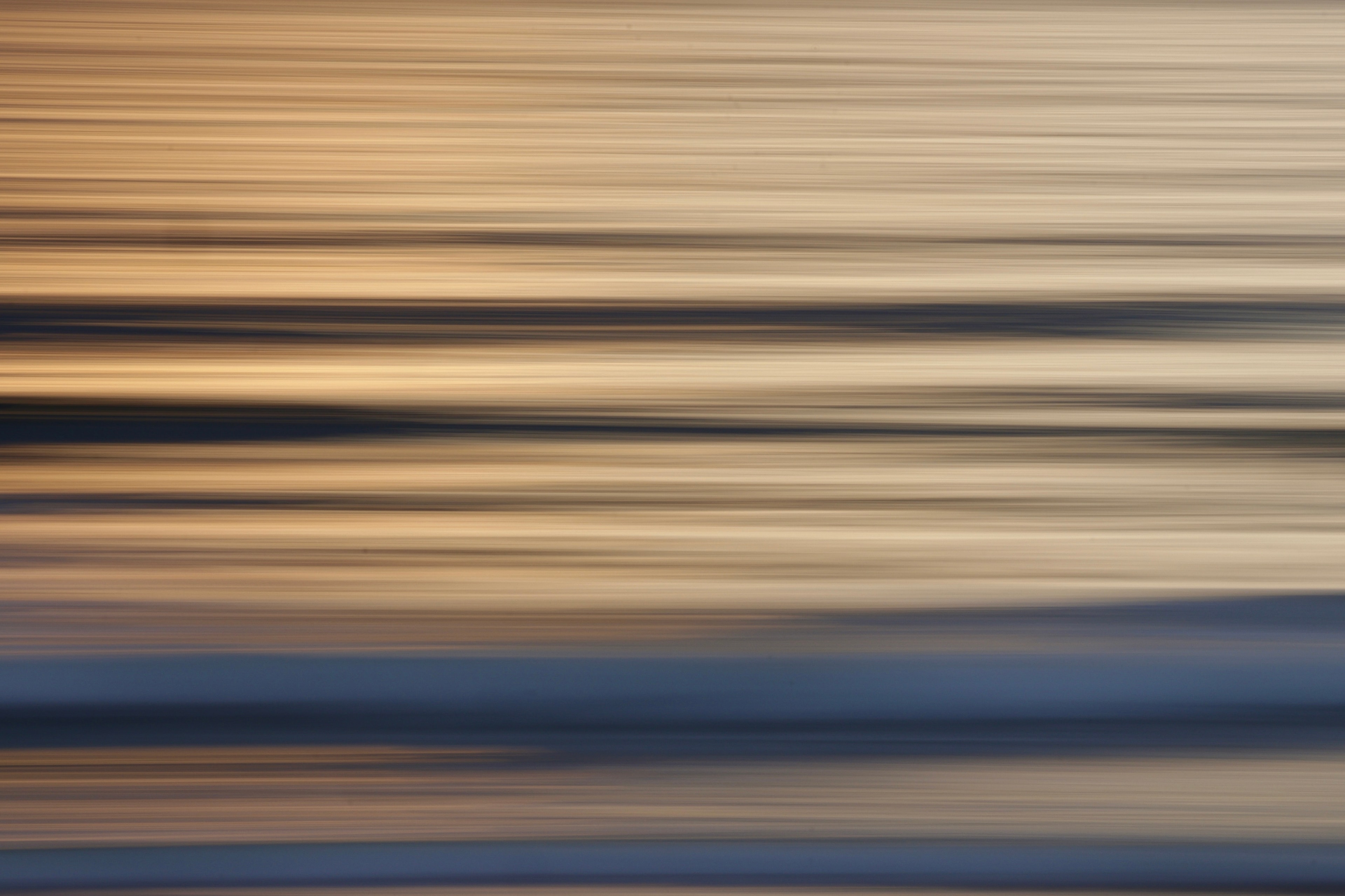 Abstract motion blur seascape with warm golden and soft blue tones