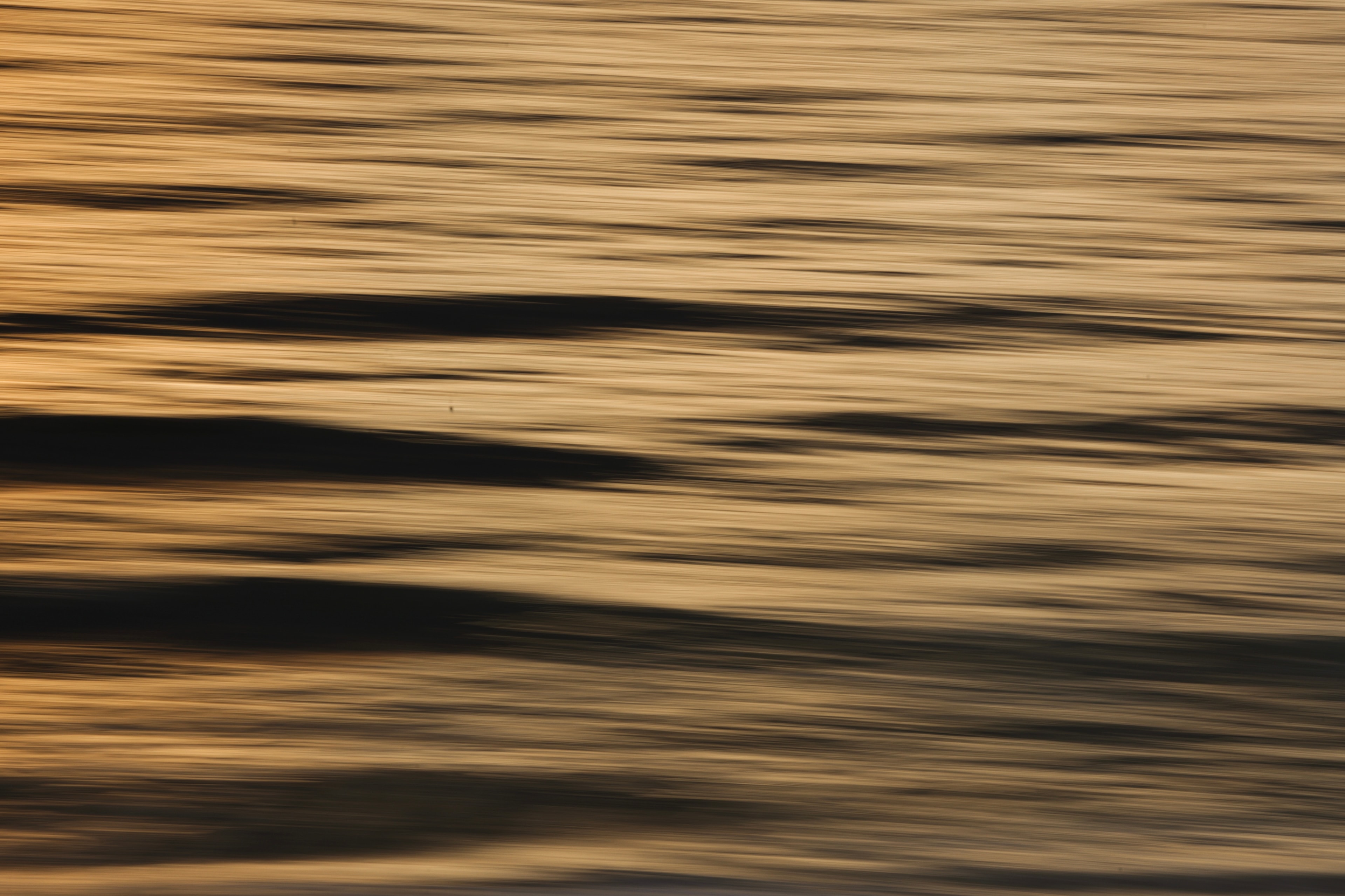 Motion blur ocean surface with rich golden and dark wave bands